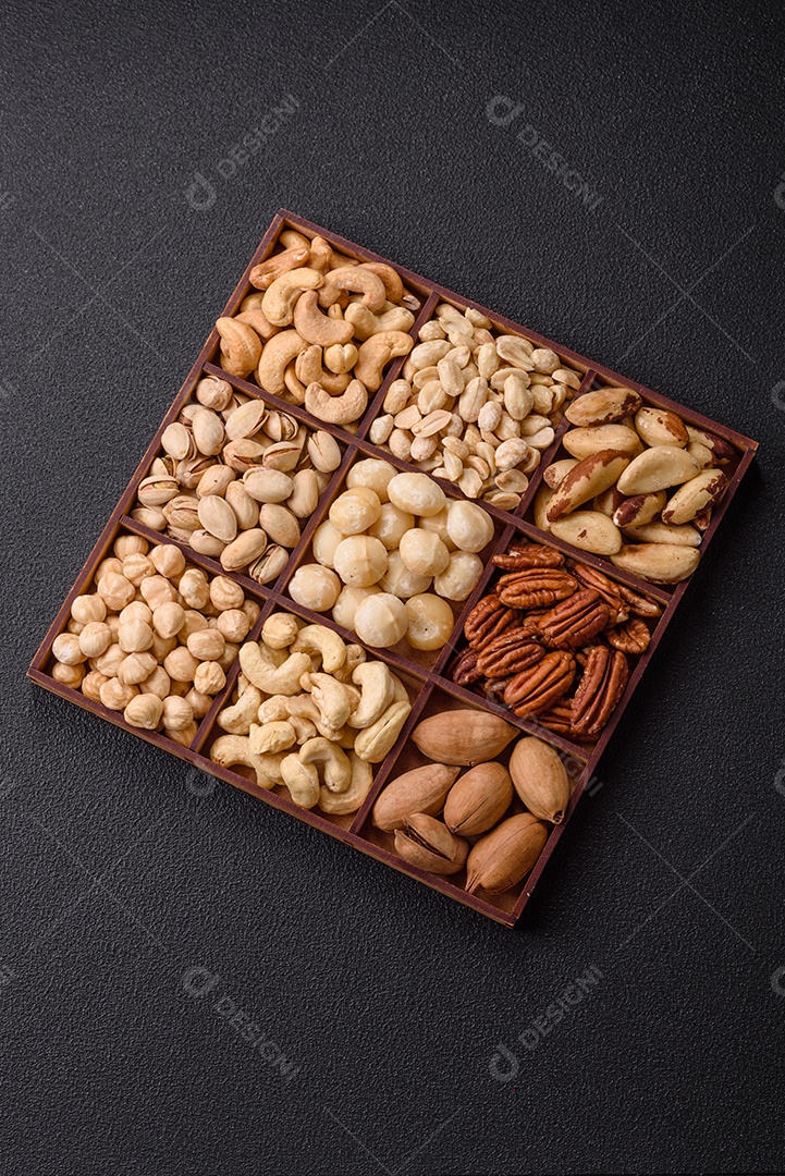 Imagem mostra uma variedade de oleaginosas, comumente chamadas de castanhas e nozes, em uma caixa dividida em compartimentos.