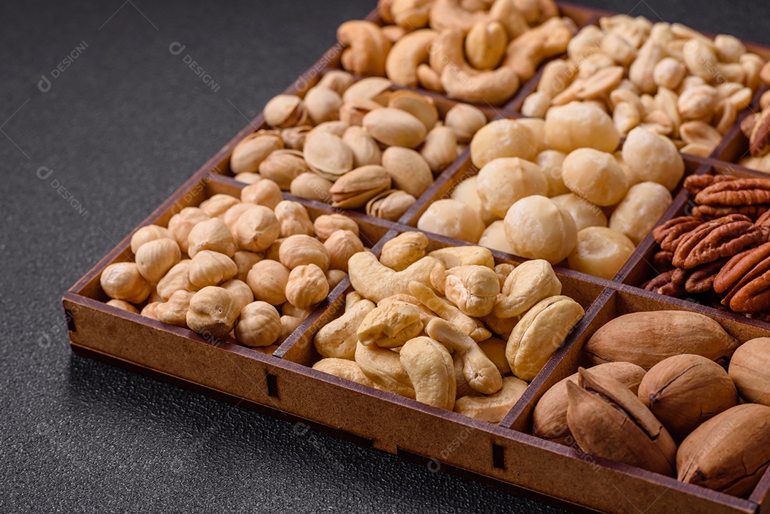 Imagem mostra uma variedade de oleaginosas, comumente chamadas de castanhas e nozes, em uma caixa dividida em compartimentos.