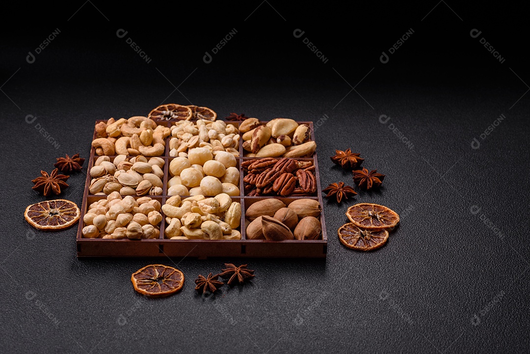 Imagem mostra uma variedade de oleaginosas, comumente chamadas de castanhas e nozes, em uma caixa dividida em compartimentos.