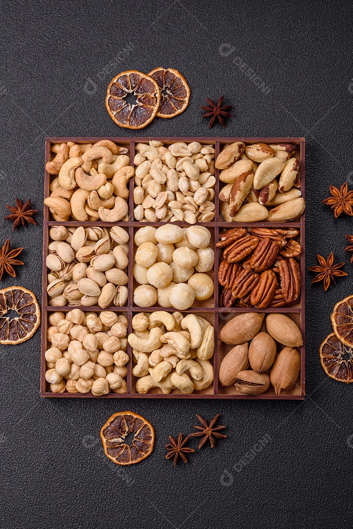 Imagem mostra uma variedade de oleaginosas, comumente chamadas de castanhas e nozes, em uma caixa dividida em compartimentos.