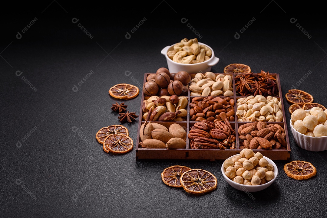 Imagem mostra uma variedade de oleaginosas, comumente chamadas de castanhas e nozes, em uma caixa dividida em compartimentos.