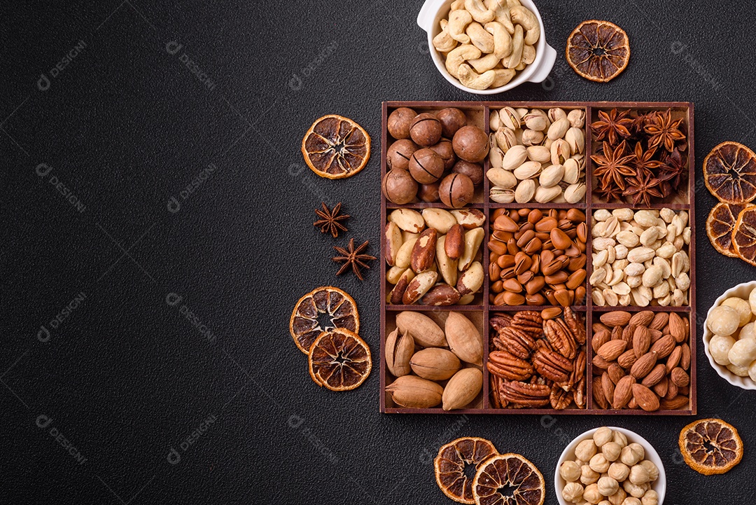 Imagem mostra uma variedade de oleaginosas, comumente chamadas de castanhas e nozes, em uma caixa dividida em compartimentos.