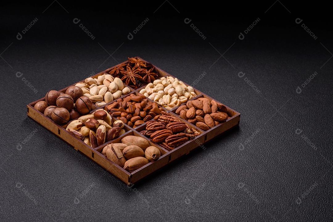 Imagem mostra uma variedade de oleaginosas, comumente chamadas de castanhas e nozes, em uma caixa dividida em compartimentos.