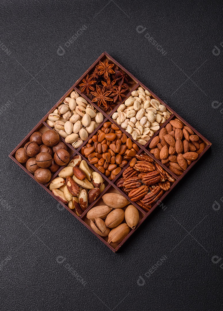 Imagem mostra uma variedade de oleaginosas, comumente chamadas de castanhas e nozes, em uma caixa dividida em compartimentos.