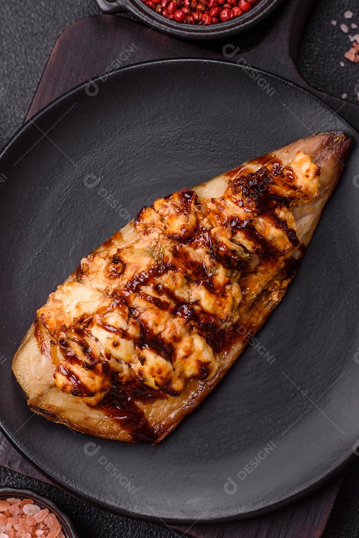 O prato na imagem parece ser um filé de cavala grelhado, servido com um molho e pimenta rosa.