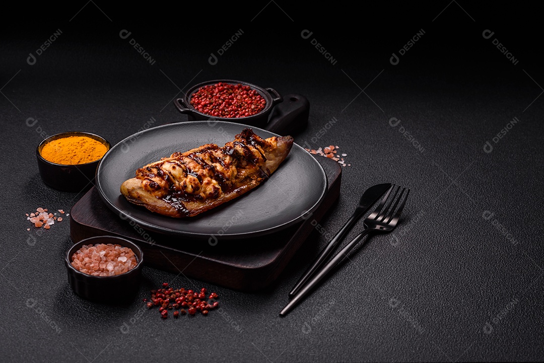 O prato na imagem parece ser um filé de cavala grelhado, servido com um molho e pimenta rosa.