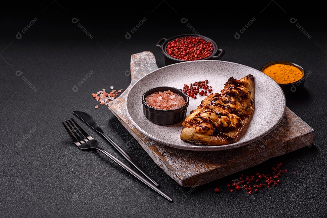 O prato na imagem parece ser um filé de cavala grelhado, servido com um molho e pimenta rosa.