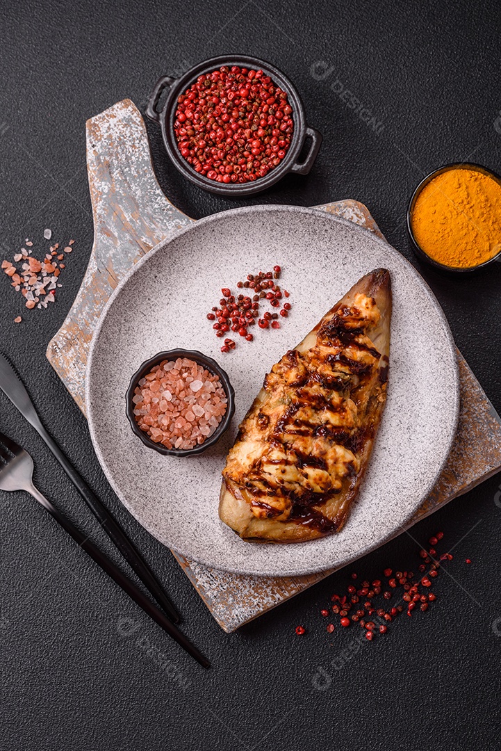 O prato na imagem parece ser um filé de cavala grelhado, servido com um molho e pimenta rosa.