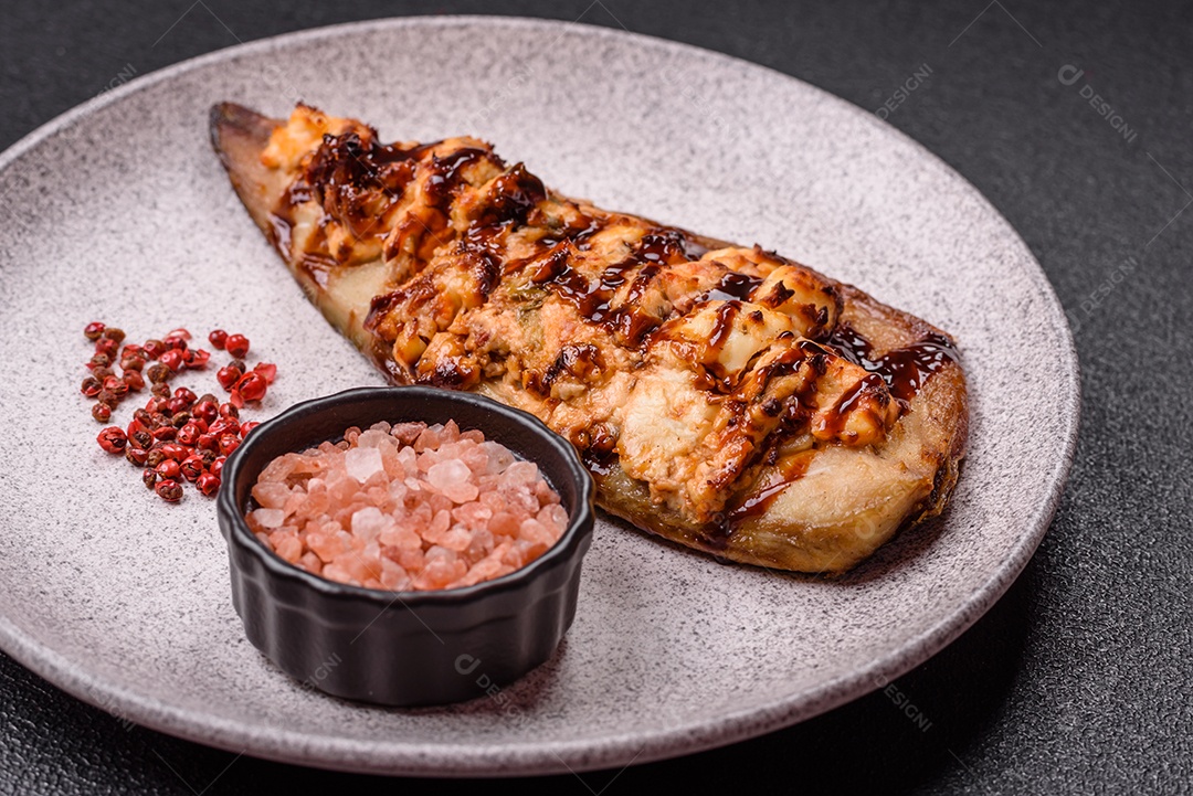 O prato na imagem parece ser um filé de cavala grelhado, servido com um molho e pimenta rosa.