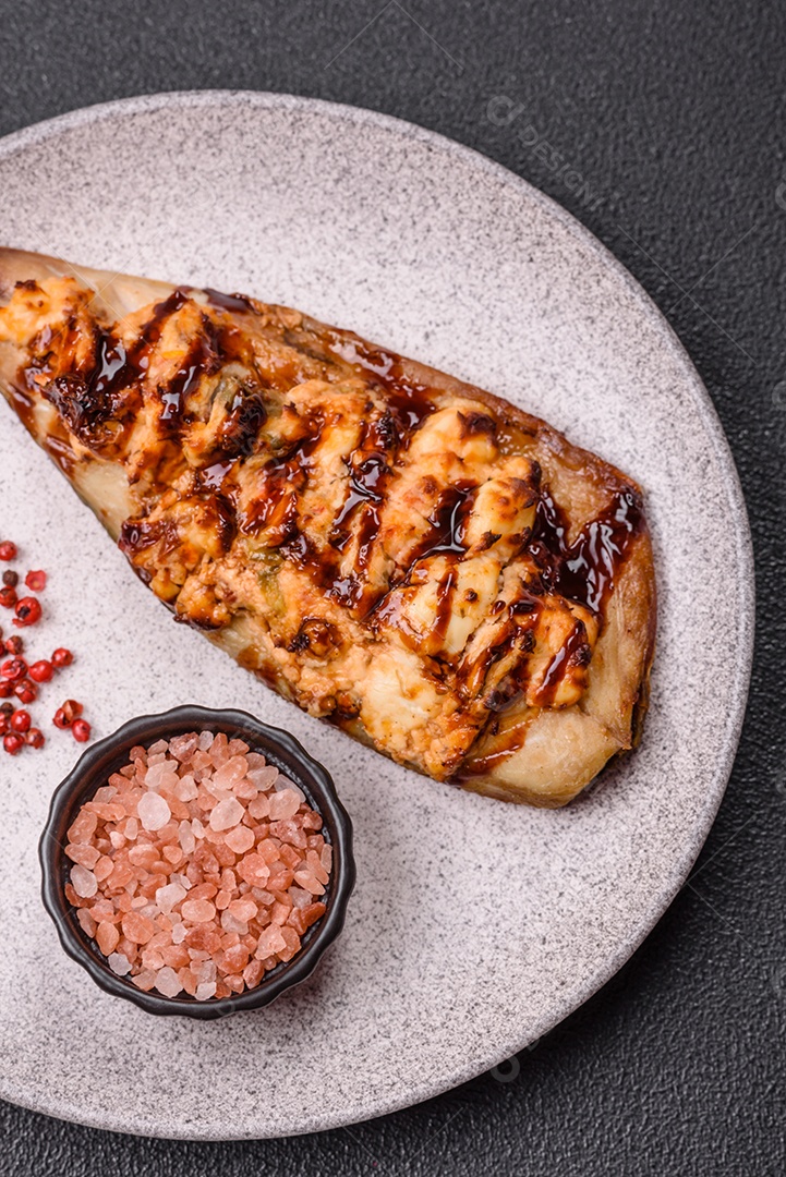 O prato na imagem parece ser um filé de cavala grelhado, servido com um molho e pimenta rosa.