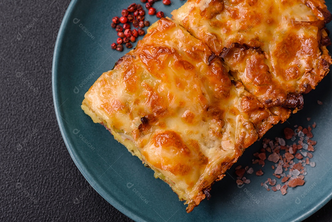 A imagem mostra um prato de lasanha com tomate cereja e pimenta rosa em grão