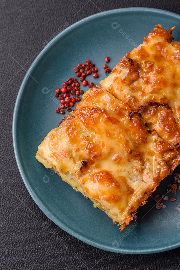 A imagem mostra um prato de lasanha com tomate cereja e pimenta rosa em grão