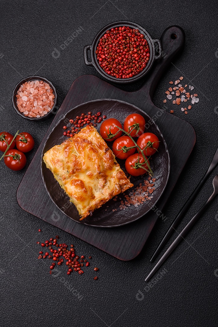 A imagem mostra um prato de lasanha com tomate cereja e pimenta rosa em grão