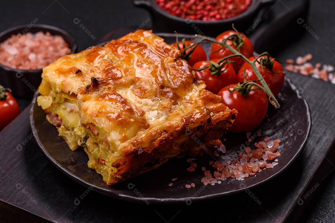 A imagem mostra um prato de lasanha com tomate cereja e pimenta rosa em grão