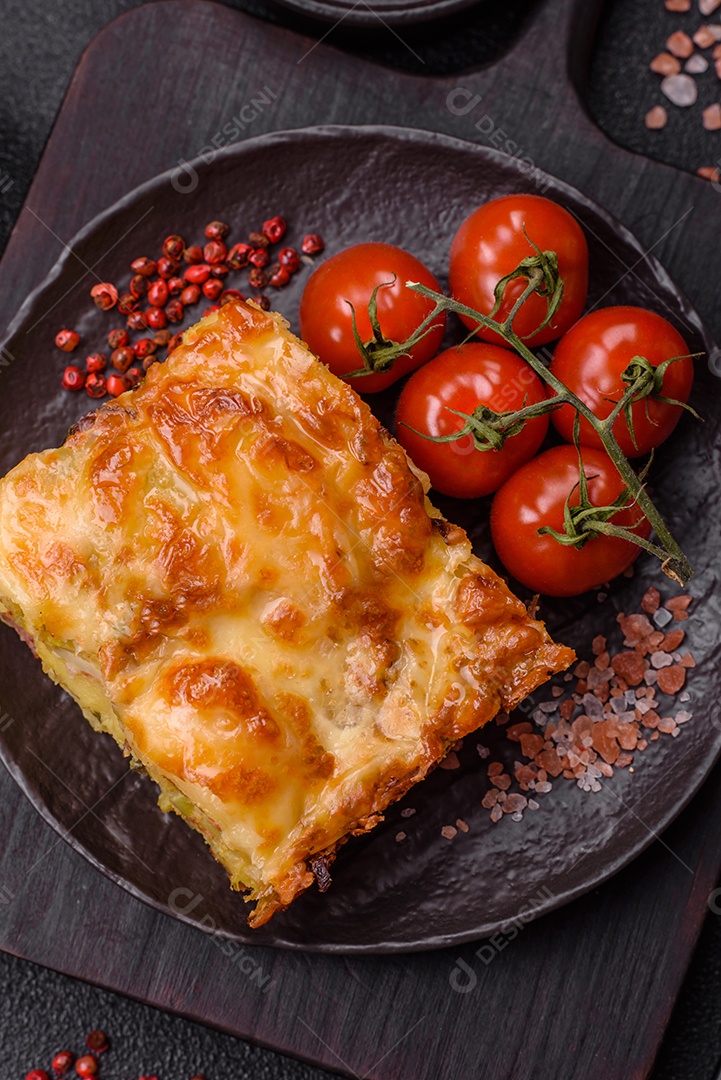A imagem mostra um prato de lasanha com tomate cereja e pimenta rosa em grão