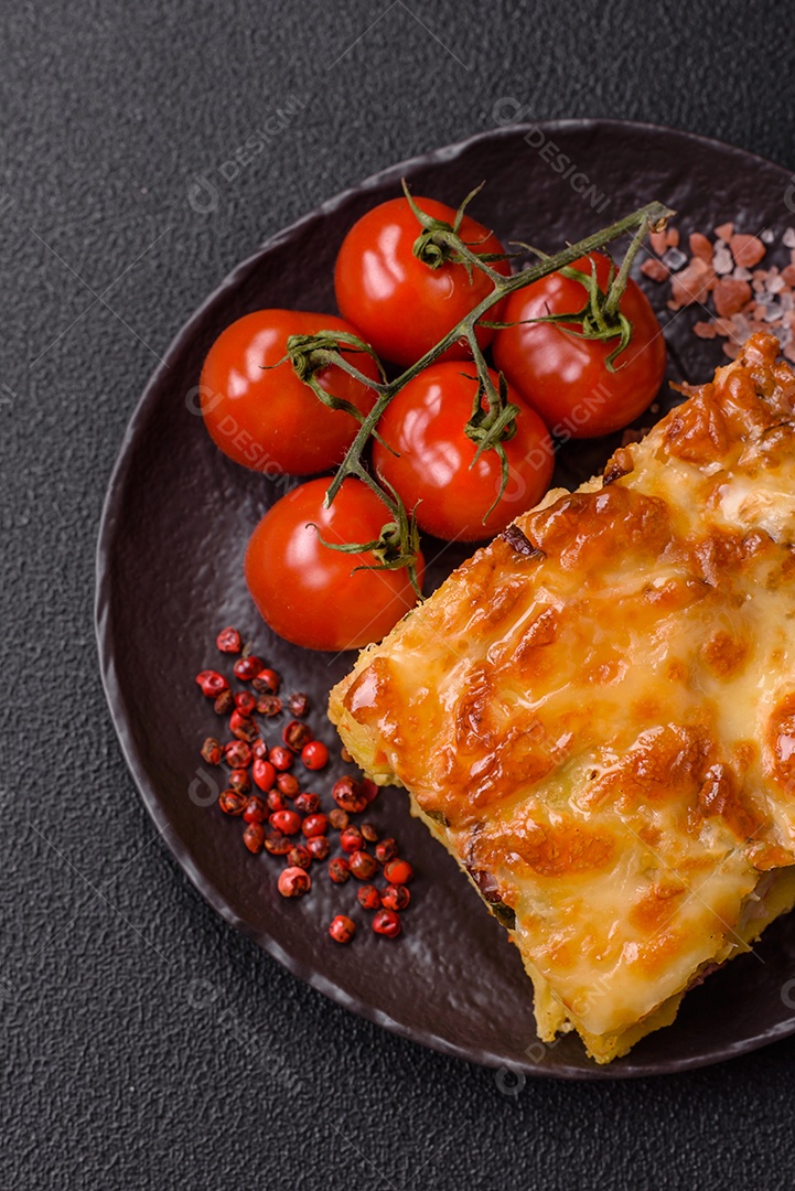 A imagem mostra um prato de lasanha com tomate cereja e pimenta rosa em grão