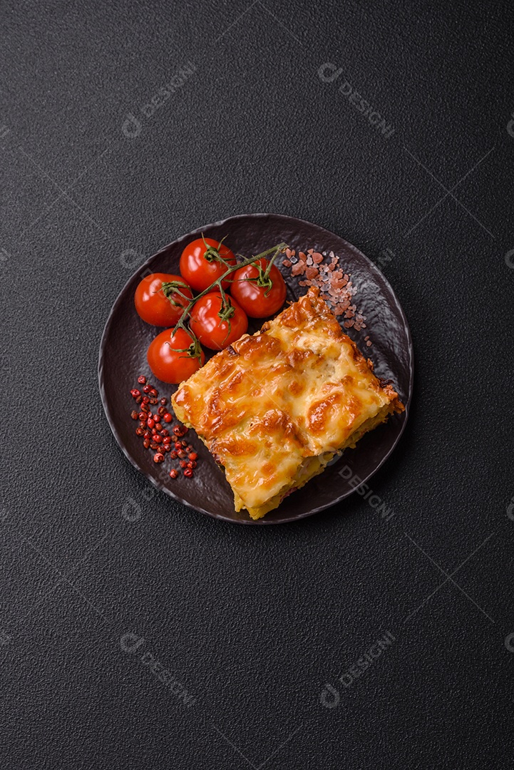 A imagem mostra um prato de lasanha com tomate cereja e pimenta rosa em grão