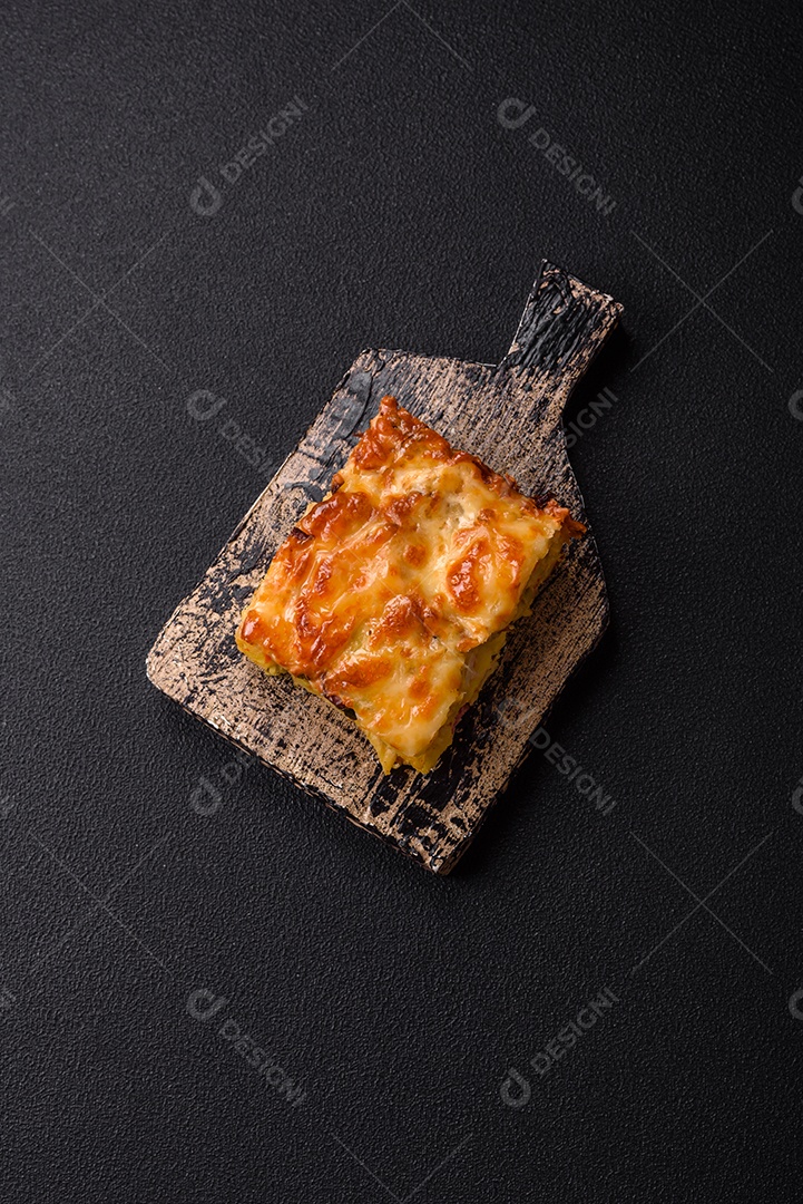 A imagem mostra um prato de lasanha com tomate cereja e pimenta rosa em grão
