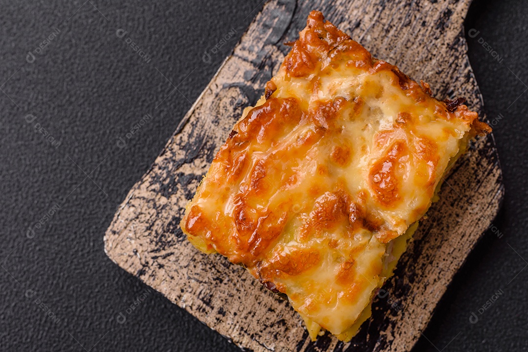 A imagem mostra um prato de lasanha com tomate cereja e pimenta rosa em grão