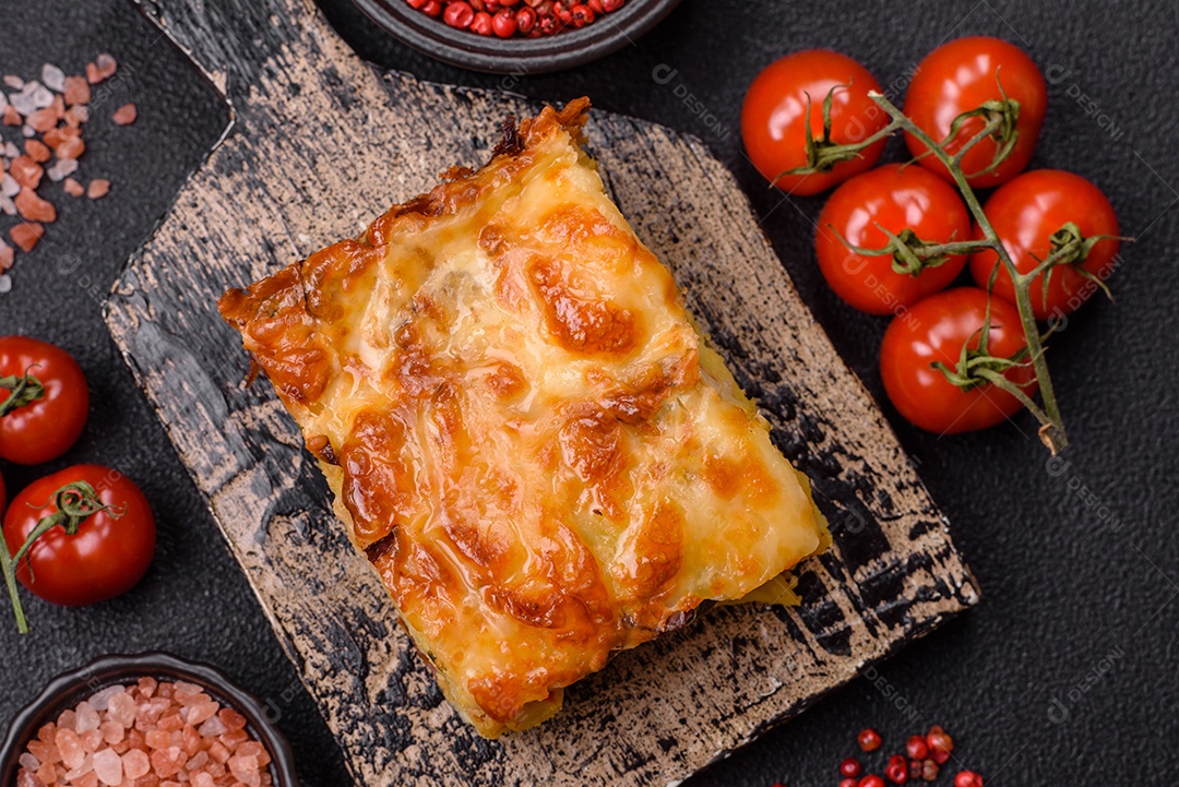 A imagem mostra um prato de lasanha com tomate cereja e pimenta rosa em grão