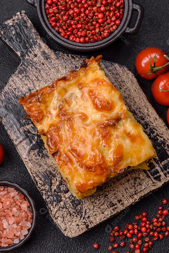A imagem mostra um prato de lasanha com tomate cereja e pimenta rosa em grão