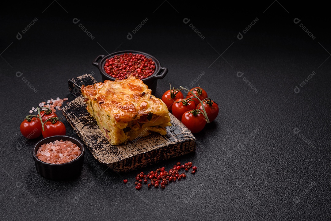 A imagem mostra um prato de lasanha com tomate cereja e pimenta rosa em grão