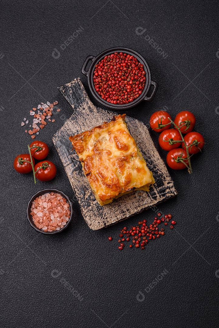 A imagem mostra um prato de lasanha com tomate cereja e pimenta rosa em grão