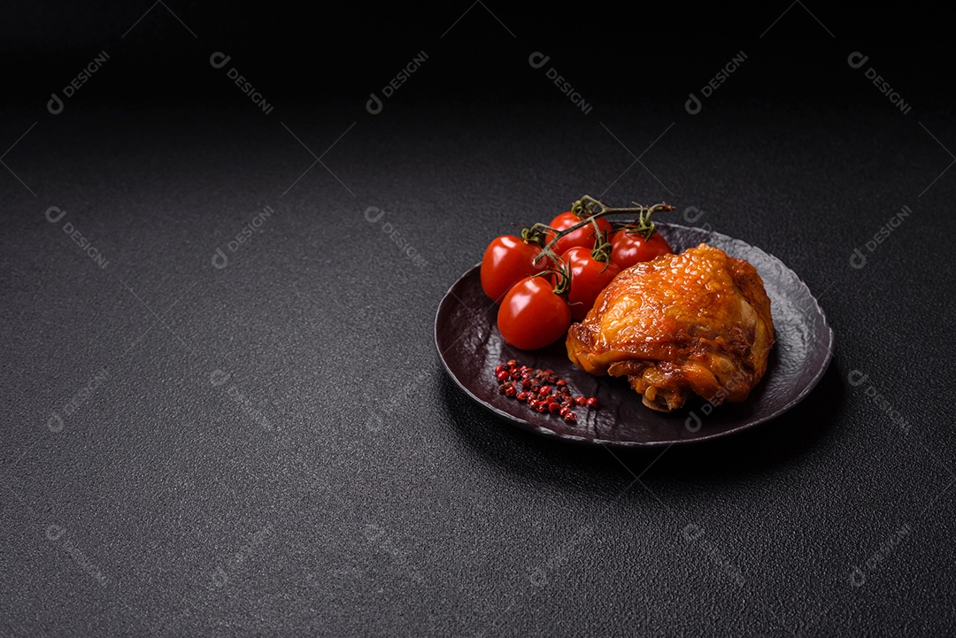 A imagem mostra sobrecoxa de frango assada, acompanhada de tomate cereja em rama e sal grosso.
