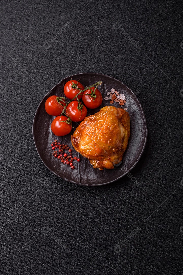 A imagem mostra sobrecoxa de frango assada, acompanhada de tomate cereja em rama e sal grosso.