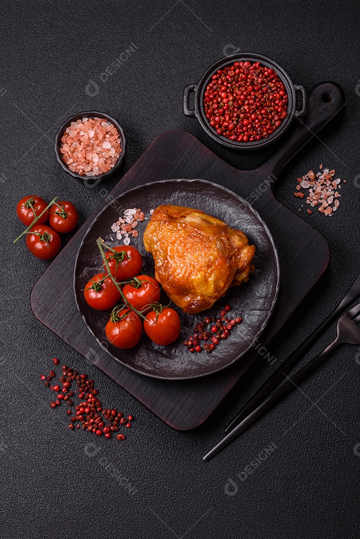 A imagem mostra sobrecoxa de frango assada, acompanhada de tomate cereja em rama e sal grosso.