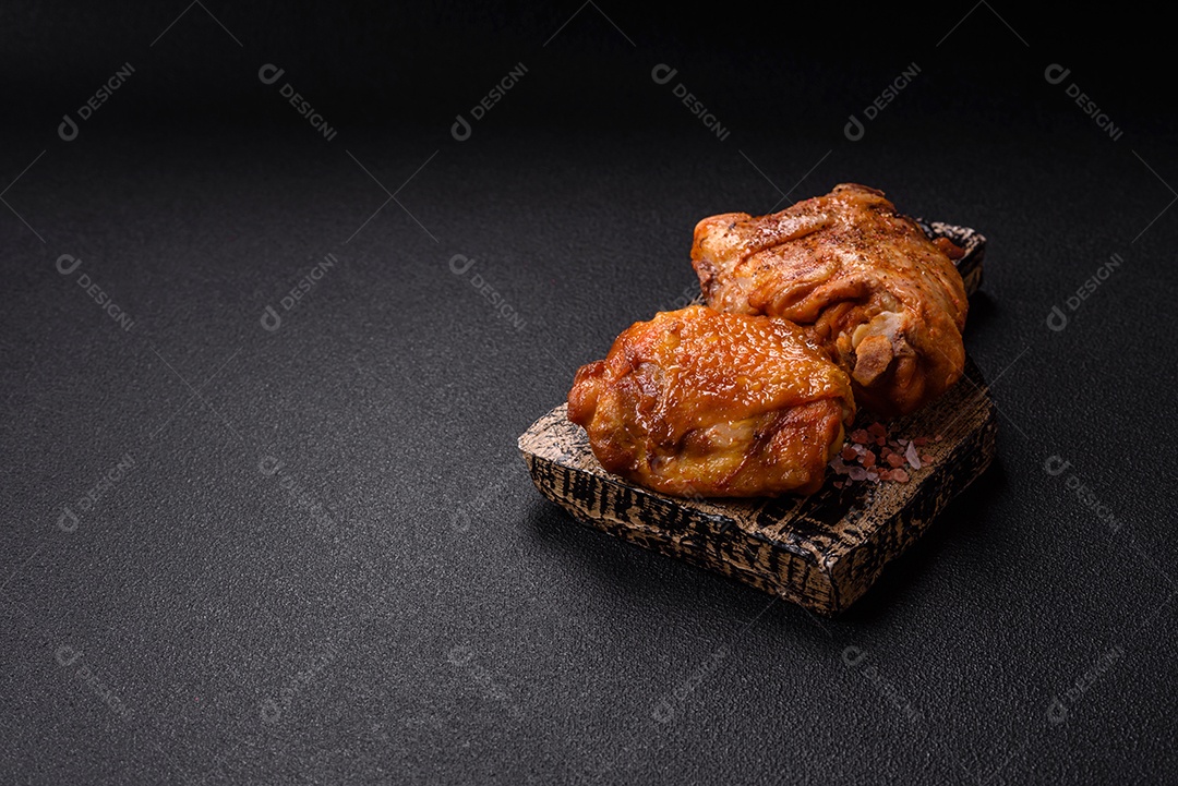 A imagem mostra sobrecoxa de frango assada, acompanhada de tomate cereja em rama e sal grosso.