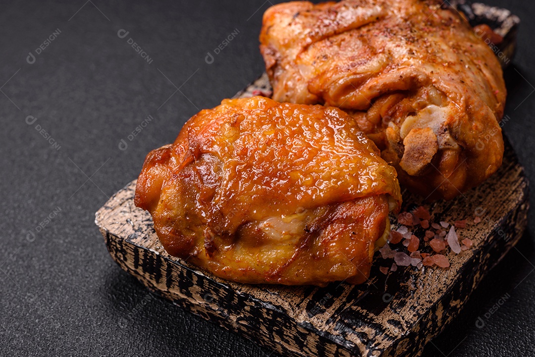 A imagem mostra sobrecoxa de frango assada, acompanhada de tomate cereja em rama e sal grosso.