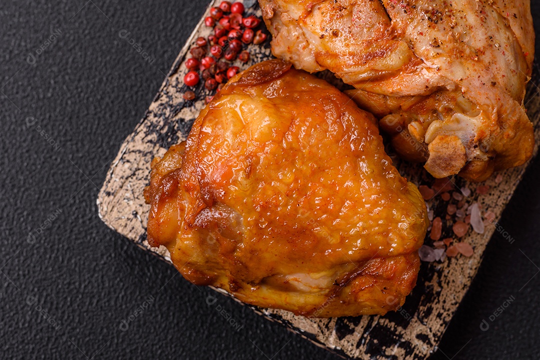 A imagem mostra sobrecoxa de frango assada, acompanhada de tomate cereja em rama e sal grosso.