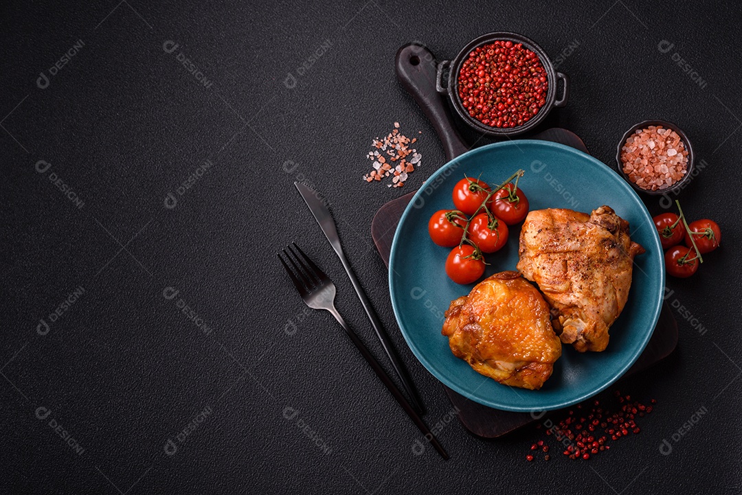 A imagem mostra sobrecoxa de frango assada, acompanhada de tomate cereja em rama e sal grosso.