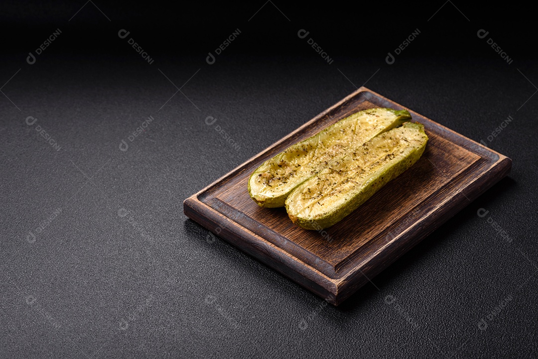 A imagem mostra uma abobrinha italiana assada ou grelhada, servida em um prato com tomate cereja e temperos