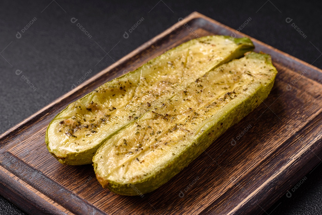 A imagem mostra uma abobrinha italiana assada ou grelhada, servida em um prato com tomate cereja e temperos