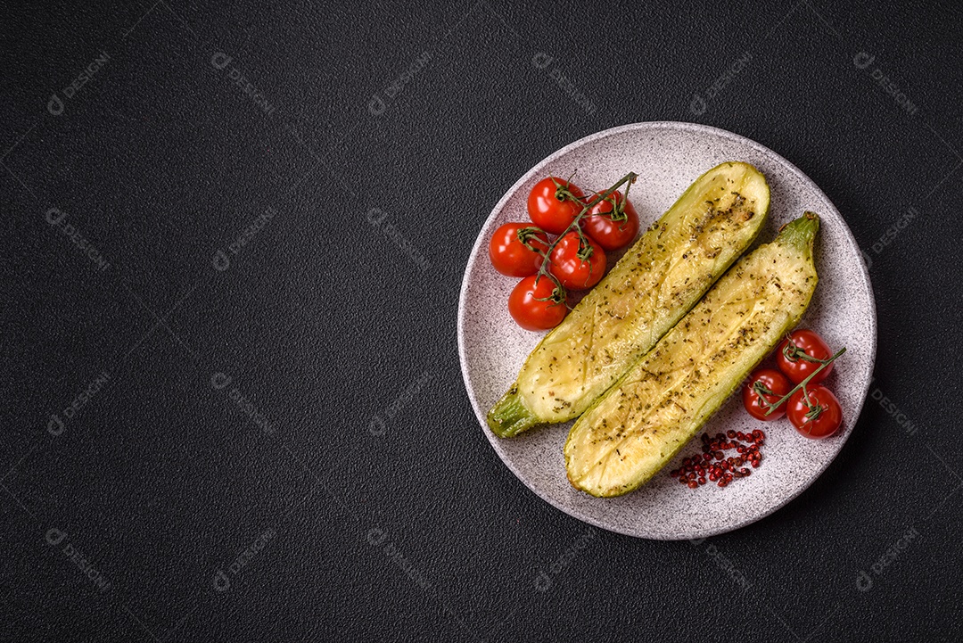 A imagem mostra uma abobrinha italiana assada ou grelhada, servida em um prato com tomate cereja e temperos