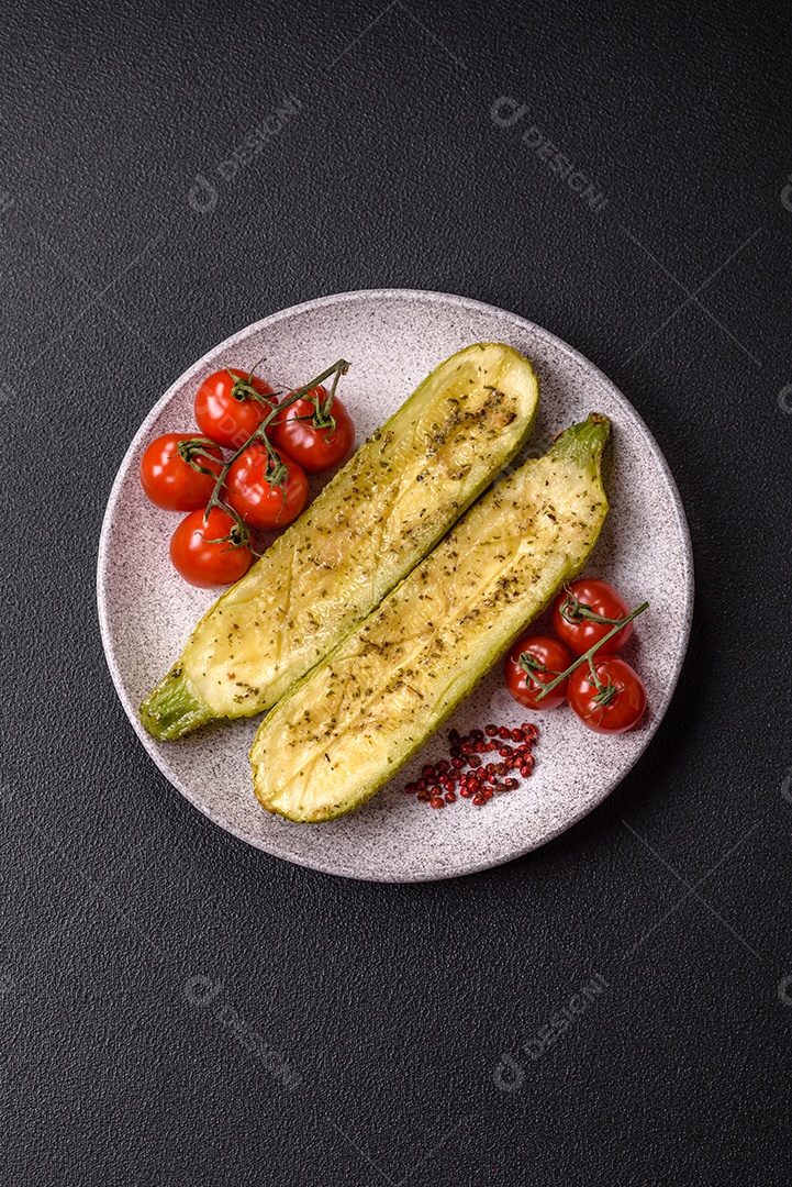 A imagem mostra uma abobrinha italiana assada ou grelhada, servida em um prato com tomate cereja e temperos