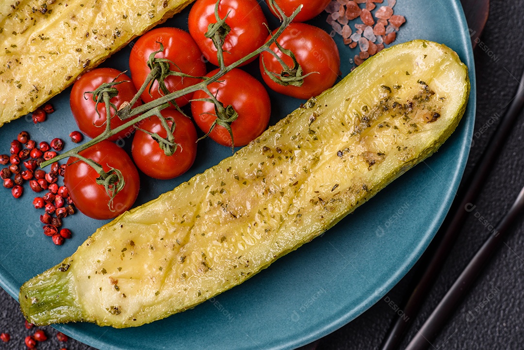 A imagem mostra uma abobrinha italiana assada ou grelhada, servida em um prato com tomate cereja e temperos