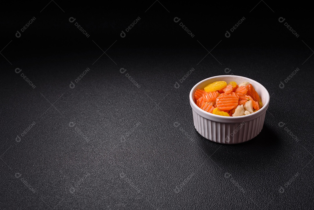 A imagem mostra uma mistura de vegetais congelados, como rodelas de cenoura e brócolis.