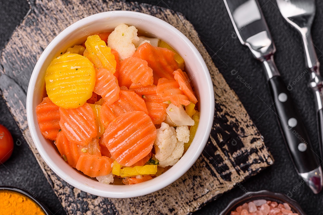 A imagem mostra uma mistura de vegetais congelados, como rodelas de cenoura e brócolis.