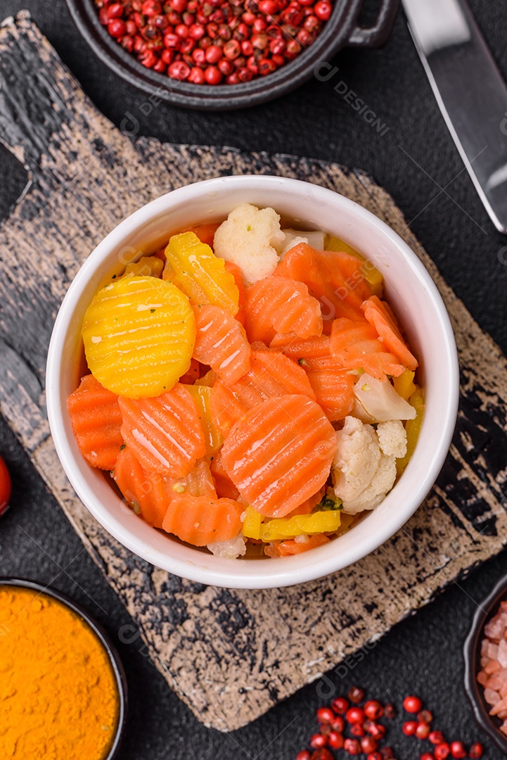 A imagem mostra uma mistura de vegetais congelados, como rodelas de cenoura e brócolis.