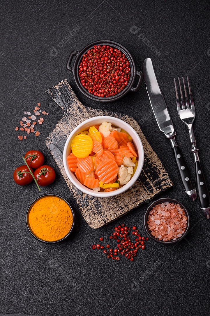 A imagem mostra uma mistura de vegetais congelados, como rodelas de cenoura e brócolis.