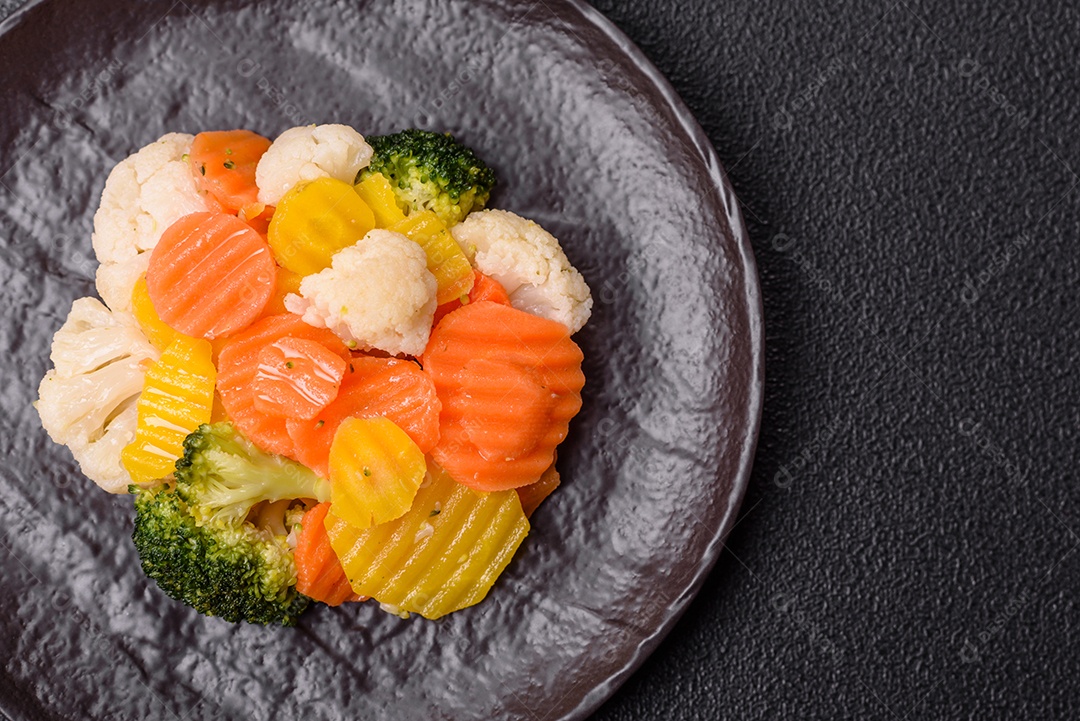 A imagem mostra uma mistura de vegetais congelados, como rodelas de cenoura e brócolis.