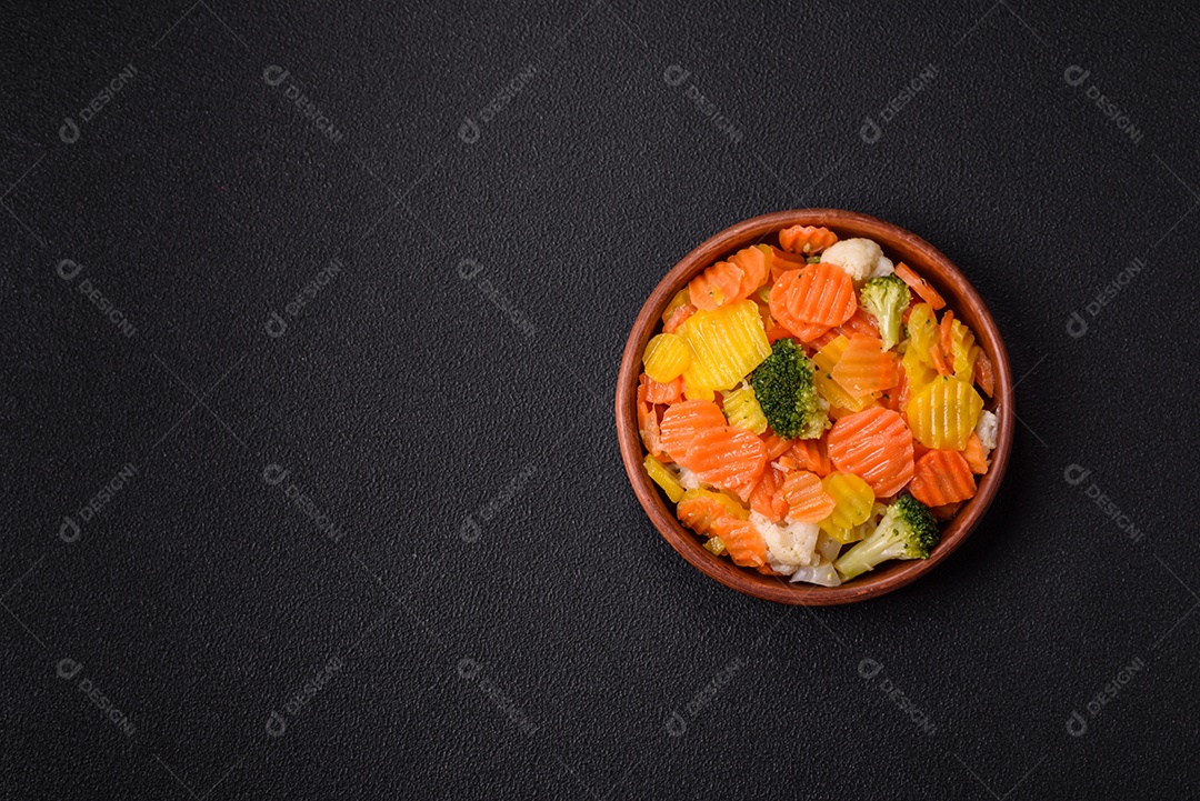 A imagem mostra uma mistura de vegetais congelados, como rodelas de cenoura e brócolis.