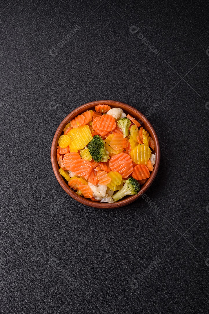 A imagem mostra uma mistura de vegetais congelados, como rodelas de cenoura e brócolis.