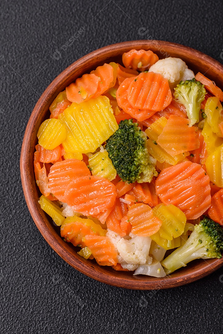 A imagem mostra uma mistura de vegetais congelados, como rodelas de cenoura e brócolis.