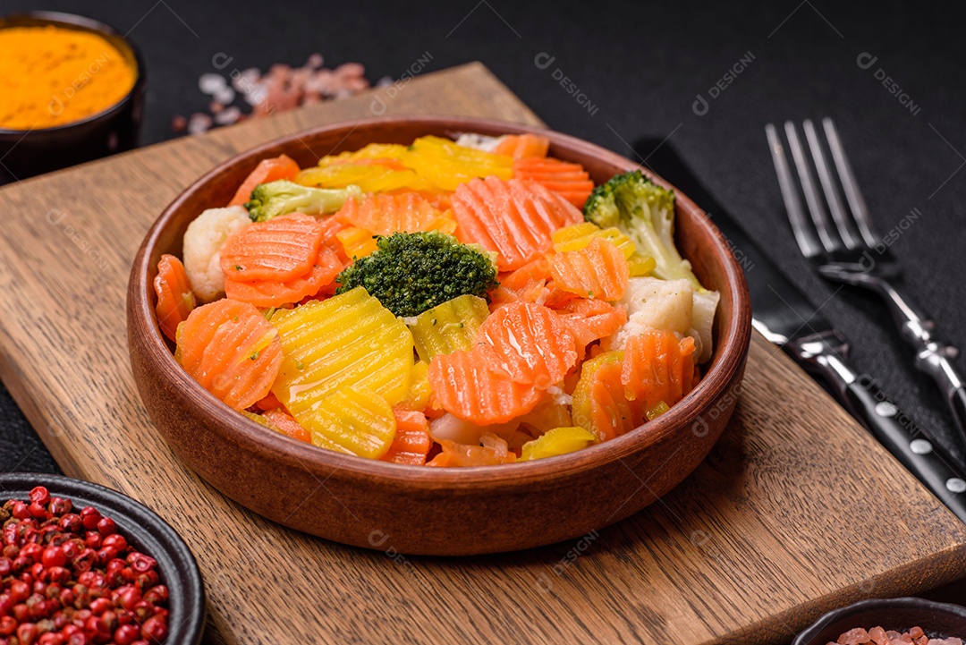 A imagem mostra uma mistura de vegetais congelados, como rodelas de cenoura e brócolis.