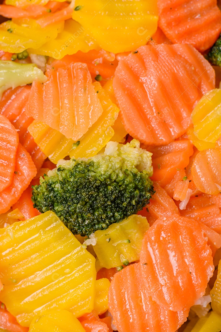 A imagem mostra uma mistura de vegetais congelados, como rodelas de cenoura e brócolis.