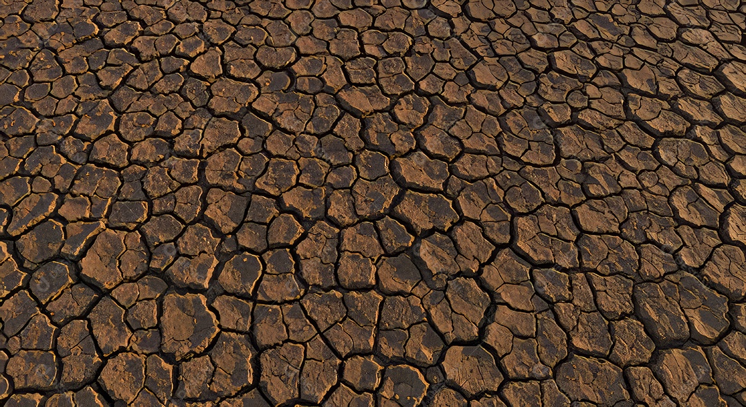 Textura de um solo rachado que é uma característica comum de áreas que sofreram seca intensa.